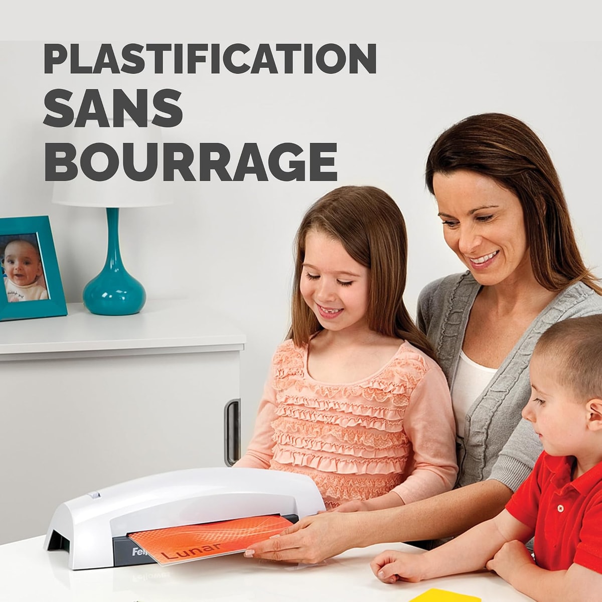 Une famille plastifie un dessin avec une plastifieuse FELLOWES Lunar