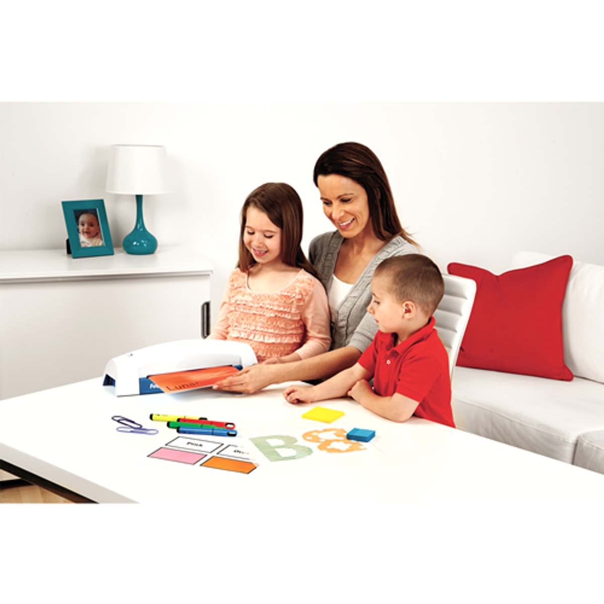 Une famille plastifie des dessins avec la plastifieuse FELLOWES Lunar+ A4