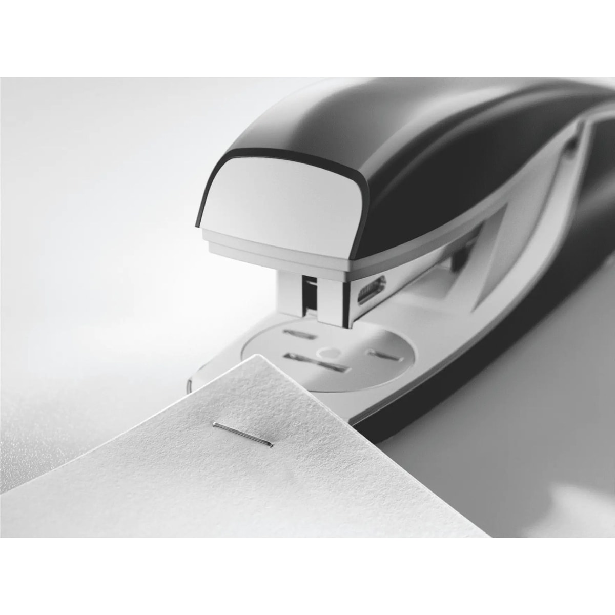 Tête de l'agrafeuse de bureau LEITZ NeXXt 5504 noire qui agrafe le coin d'une feuille.
