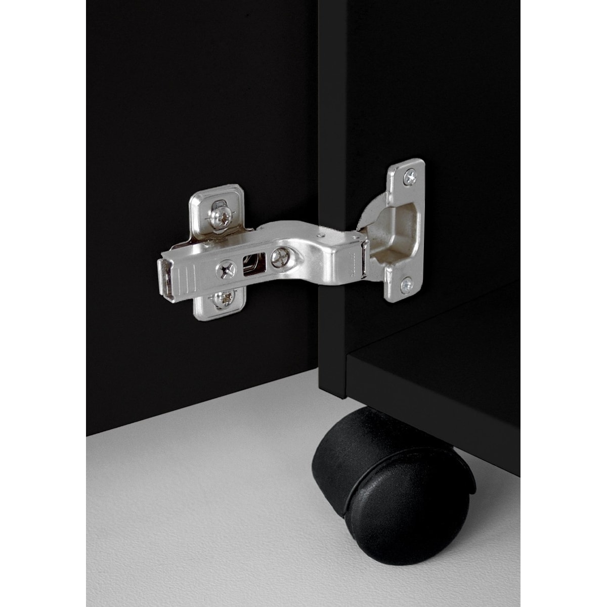 Charnière de la porte et roulette pivotante sous le meuble noir.