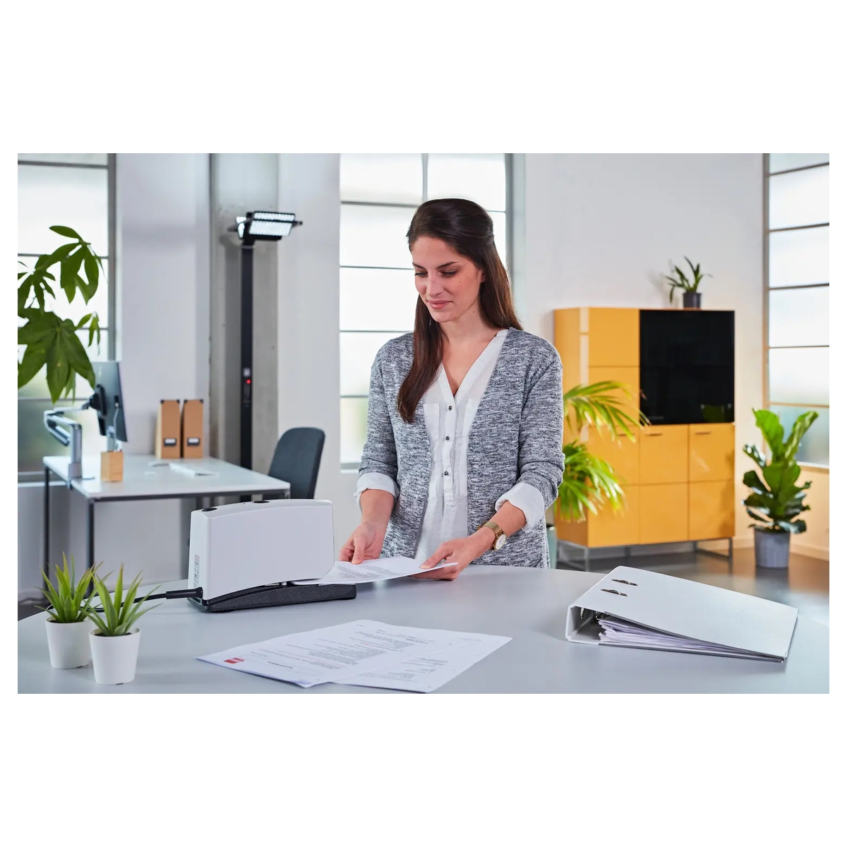 Agrafeuse électrique NOVUS B 100EL utilisée pour agrafer un document.