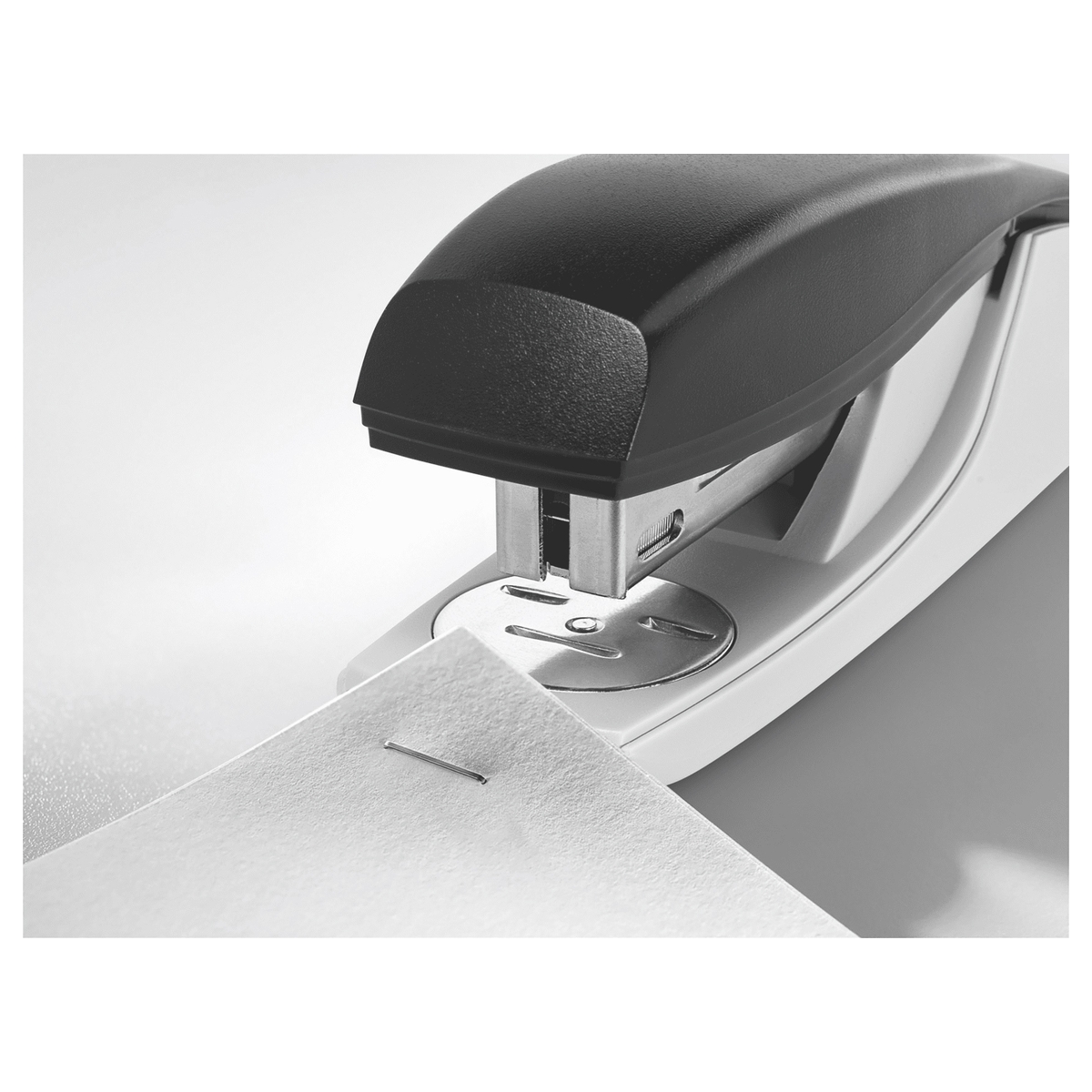 Tête de l'agrafeuse de bureau LEITZ NeXXt 5500 noire qui agrafe le coin d'une feuille.