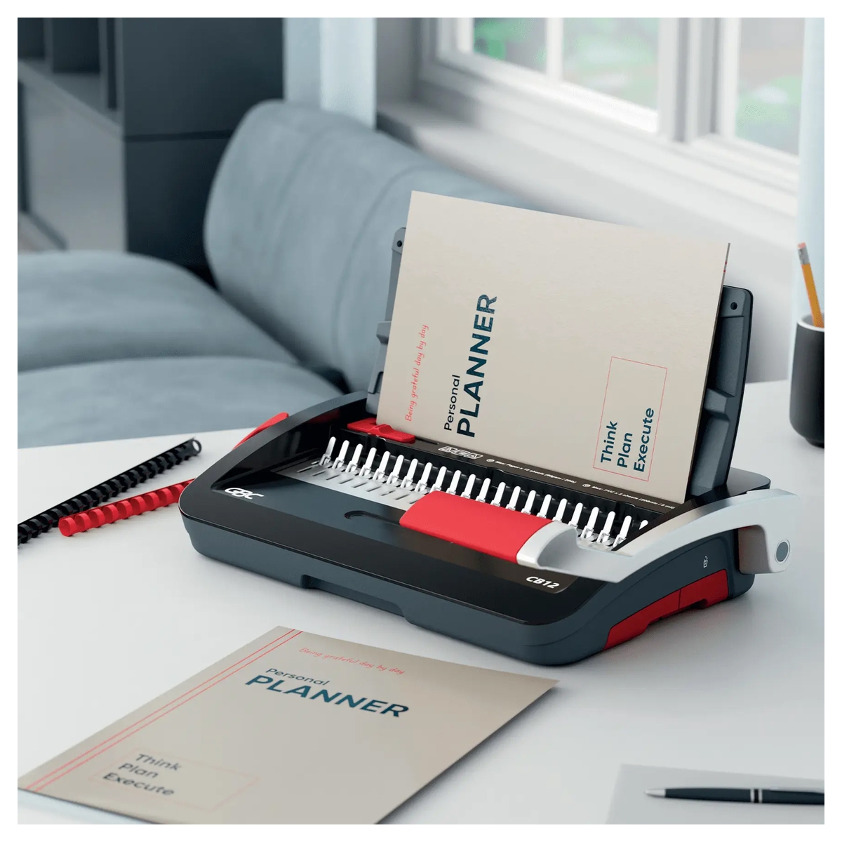 Perforelieuse GBC CombBind CB12 sur un bureau, avec un document relié au peigne plastique.