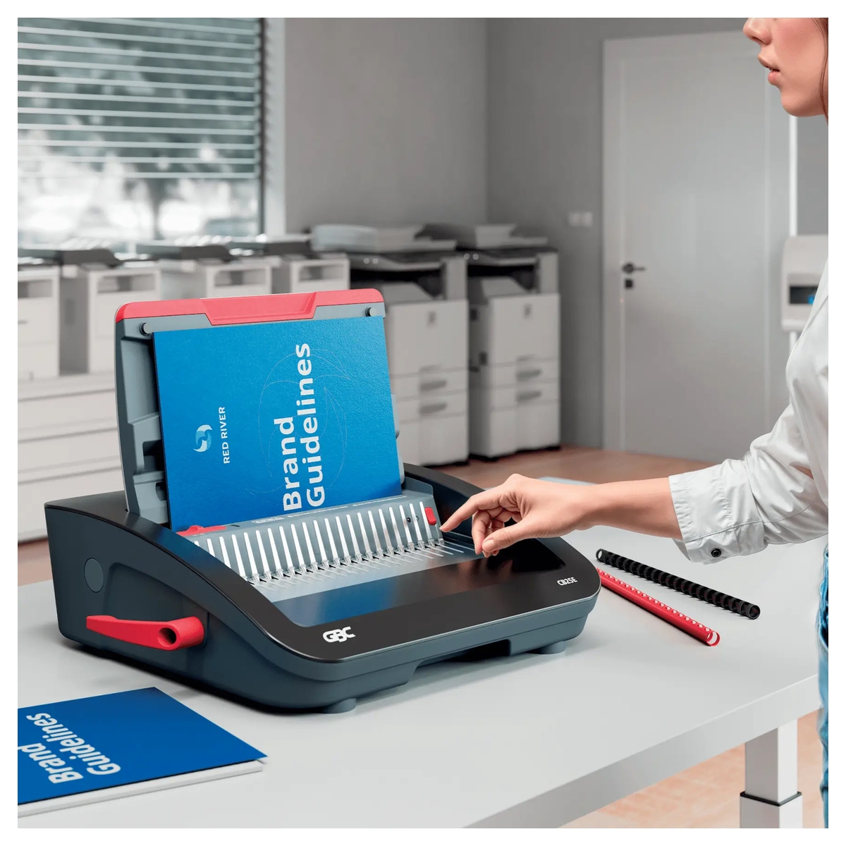 Perforelieuse électrique GBC CombBind CB25E en usage dans un bureau, avec un rapport à relier.
